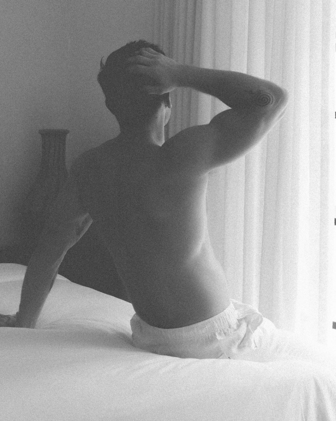 Man waking up in bed in the morning, representing a calm and gentle start to the day as part of a simple morning routine.