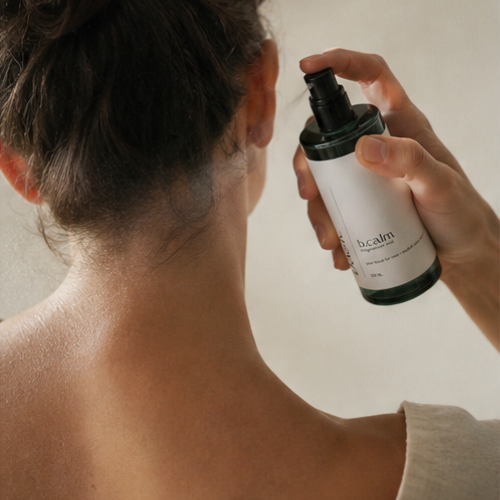 Hand spraying b.calm magnesium mist onto skin before bed