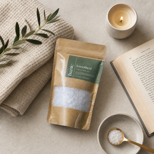 b.soothed bath soak styled with candle and bath props
